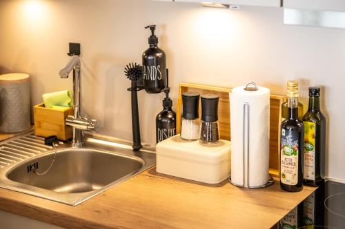 eine Küchentheke mit Spüle und Weinflaschen in der Unterkunft FeWo Ahrperle-modernes Apartment-Balkon-Kurviertel in Bad Neuenahr-Ahrweiler