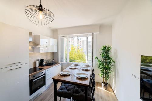 une cuisine avec une table et des chaises dans une cuisine dans l'établissement Appartement climatisé gare St-Charles, à Marseille