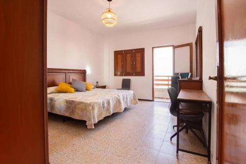 ein Schlafzimmer mit einem Bett mit gelben Kissen und einem Schreibtisch in der Unterkunft Casa Sunshine Paradise in Vecindario