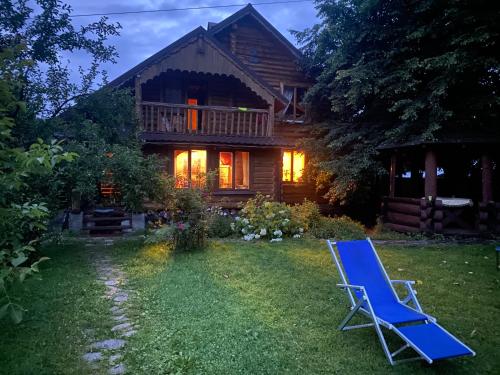 a blue lawn chair in front of a house at Oselia Lada in Tukhlya