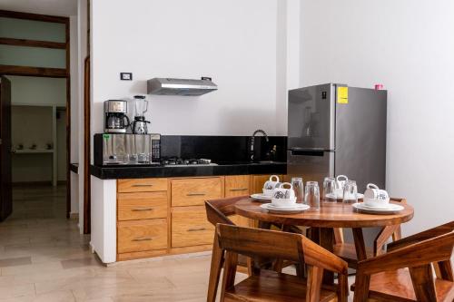 a kitchen with a wooden table and a refrigerator at Hubun Hotel Boutique in Los Ayala