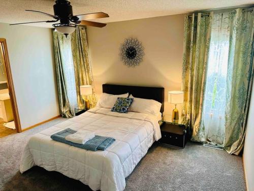 a bedroom with a bed and a ceiling fan at The Falmouth Villa with Peloton Bike in Shakopee