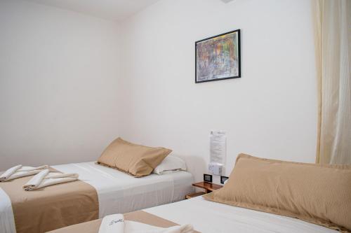 a bedroom with two beds and a picture on the wall at Hubun Hotel Boutique in Los Ayala