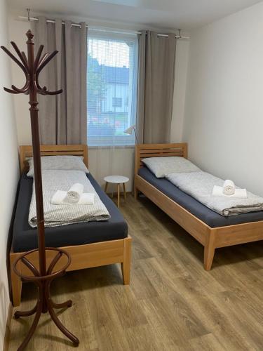 1 dormitorio con 2 camas y ventana en Apartmány Mikulčice, en Mikulčice