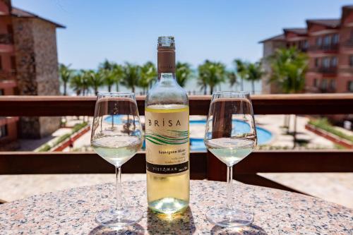 two glasses of white wine sitting on a table at [KaririBeach319] Incrível Flat 2qts à beira-mar in Cumbuco