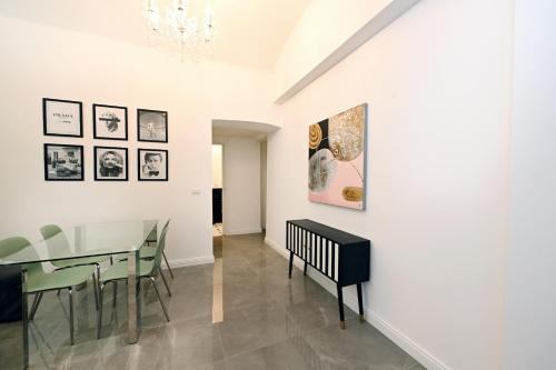 een eetkamer met een glazen tafel en groene stoelen bij VATICAN DESIGN APARTMENTS in Rome