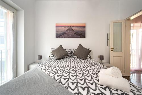 a bedroom with a large bed with white walls at Seaside Apartment Genova in Genova