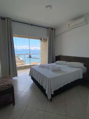 a bedroom with a bed and a large window at Verde e Mar in Angra dos Reis
