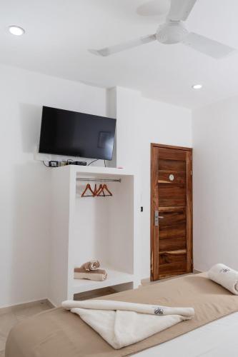 a room with a bed and a tv on a wall at Hubun Hotel Boutique in Los Ayala