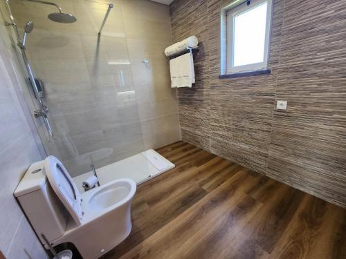 ein Bad mit einem WC und einer Dusche in der Unterkunft Rosegarden View in Velas