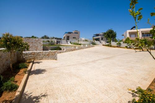 a road with houses in the background at Imperium Luxury Villas-Sauna, Jacuzzi, Heated Pool & Gym-Chania in Kato Galatas