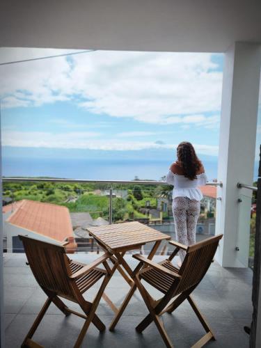 a woman standing on a balcony looking out at the ocean at Rosegarden View in Velas