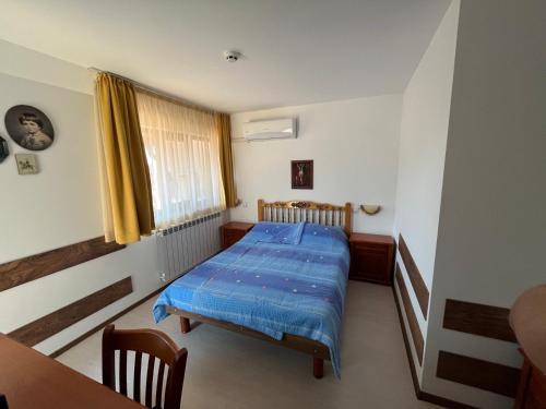 a bedroom with a bed with a blue comforter at Centaur Family Hotel in Rila