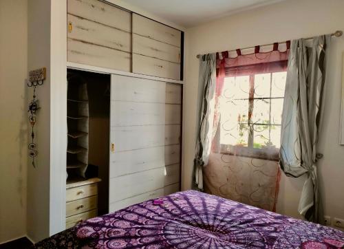 a bedroom with a purple bed and a window at Nature Finca Apartment - Pure Relaxation in Villa de Mazo