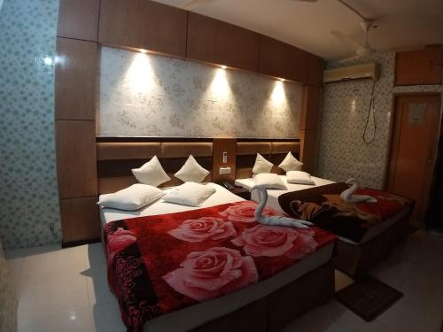 two beds in a hotel room with roses on them at Saint Martin Resort in Cox's Bazar