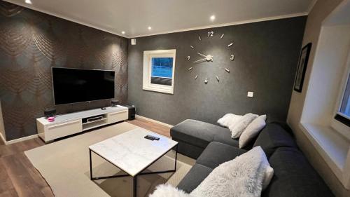 sala de estar con sofá y reloj en la pared en Holiday Home Ljungskile en Ljungskile