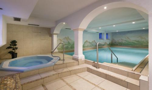 a large bathroom with a tub in the middle at Hotel Bergland in Cadipietra