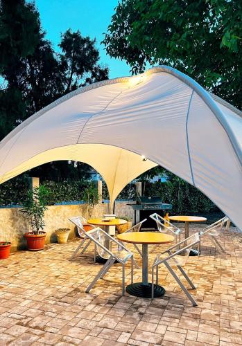 a large white umbrella over tables and chairs at Excelsior INN in Turda
