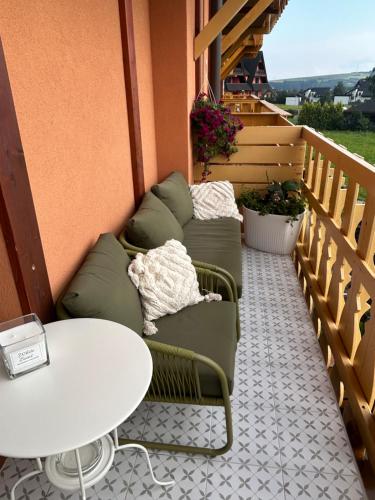 a patio with two chairs and a table on a balcony at ApartLiv in Veľká Lomnica