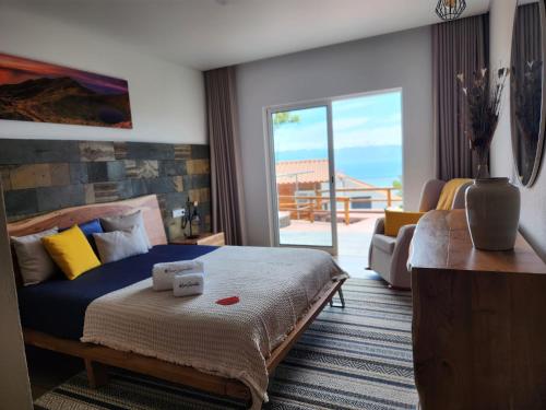 a bedroom with a bed with a view of the ocean at Rosegarden View in Velas