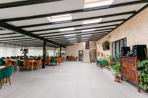 uma sala de jantar com mesas e cadeiras num edifício em Pensiunea Casa de Vis em Bughea de Sus