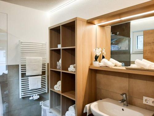 een badkamer met een wastafel, een toilet en een spiegel bij Hornblick Suite *NEW* Stylish 1BR + Netflix in Kirchdorf in Tirol