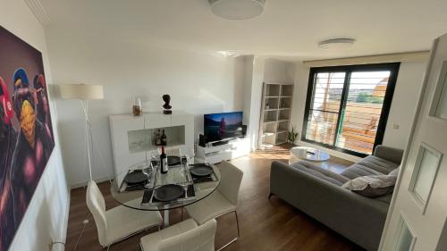 a living room with a glass table and a couch at Atico Canet de Berenguer in Canet de Berenguer