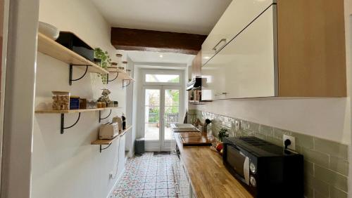 - une cuisine avec évier et four micro-ondes dans l'établissement L'Escapade de Pierrefonds par Your Sweet Loc, à Pierrefonds