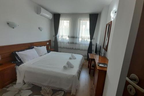 a small bedroom with a white bed and a window at Diamond Heights apartament in Bansko