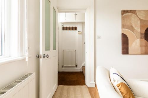 um corredor com uma porta branca e uma janela em The Broadway Bath - 2 Bedrooms with parking, Central Bath em Bath