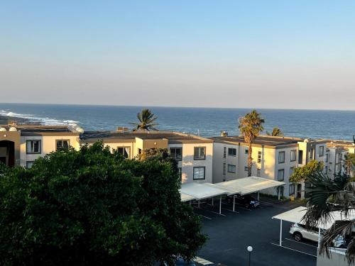 una fila di edifici con l'oceano sullo sfondo di 196 Laguna La Crete a Uvongo Beach