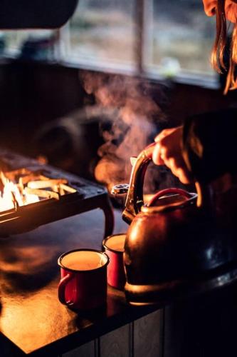 a tea kettle and two cups on a stove at The Bothy, Ben Damph Estate in Shieldaig