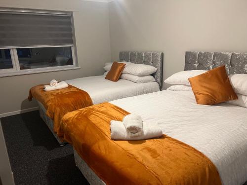 um quarto com duas camas com toalhas em The Coral 24 Guest House MilBrook Southampton em Southampton