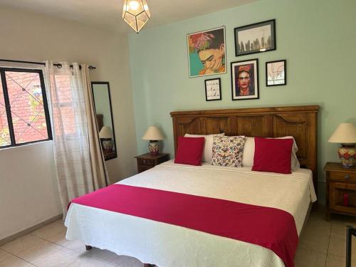 a bedroom with a large bed with red and white sheets at Casa Matia Bed and Breakfast in San Miguel de Allende