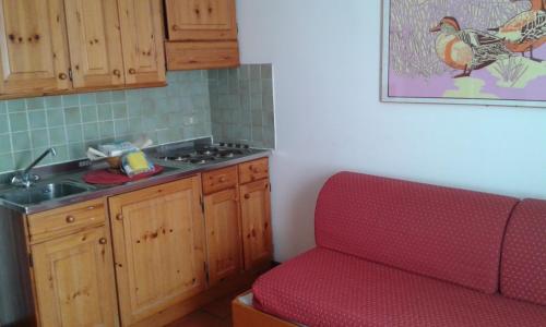 una cocina con un sofá rojo junto a un fregadero en Residence Cervinia Due - Maisonnette nr A7A04, en Breuil-Cervinia