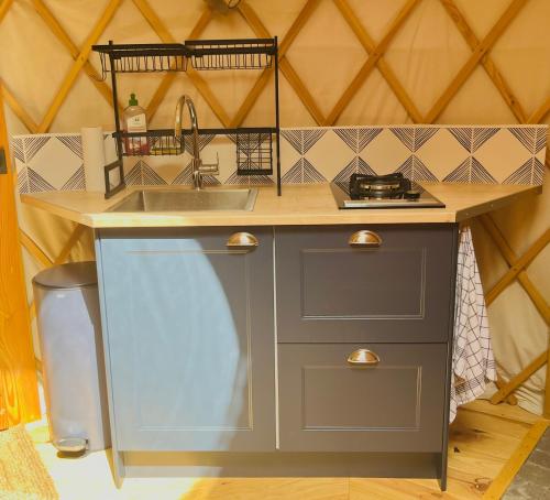 eine kleine Küche mit einer Spüle und einer Theke in der Unterkunft Aux Étangs de Jourgnac - Yourte in Jourgnac