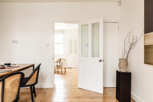 a room with a white door and a table and chairs at The Broadway Bath - 2 Bedrooms with parking, Central Bath in Bath