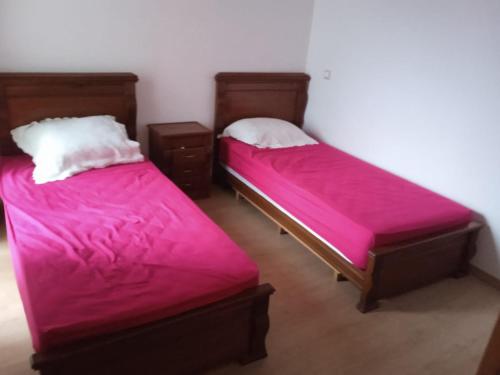 two beds with pink sheets in a room at TAMARIs in Tamaris