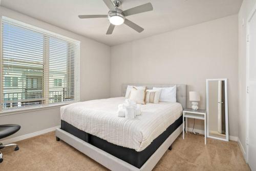 1 dormitorio blanco con 1 cama y ventilador de techo en 1BRModern Retreat-Mins to Med Center en Houston