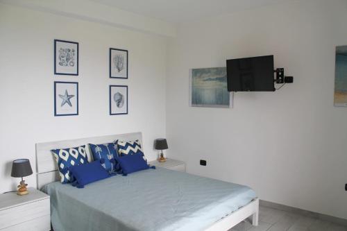 um quarto com uma cama e uma televisão na parede em GATTI e MARE em Salerno