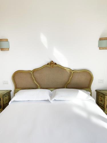 1 dormitorio con 1 cama con sábanas y almohadas blancas en B&B ISOLA Messina, en Messina