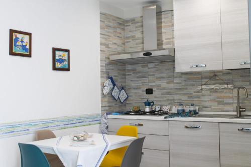 a kitchen with a table with chairs and a sink at GATTI e MARE in Salerno