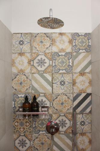 a bathroom with a tiled wall with a light at Affittacamere Medusa in Florence