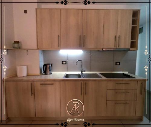 a kitchen with wooden cabinets and a sink at Ajro Rooms in Struga