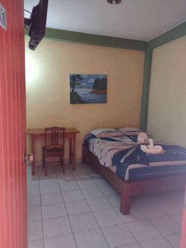 een slaapkamer met een bed, een tafel en een stoel bij HOTEL SOL Y LUNA in Iquitos