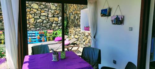 a table with a purple table cloth in front of a stone wall at Nature Finca Apartment - Pure Relaxation in Villa de Mazo