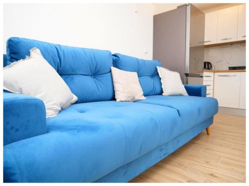 een blauwe bank met kussens in de woonkamer bij House Luketini dvori in Blizna Donja