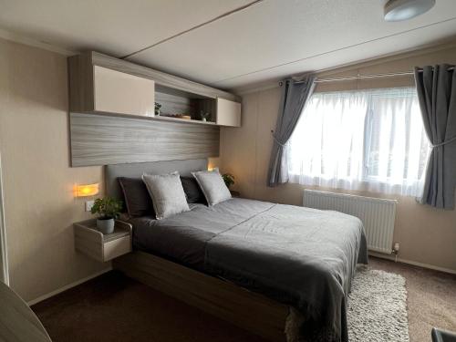 Schlafzimmer mit einem Bett und einem Fenster in der Unterkunft Forest lodge in Sway