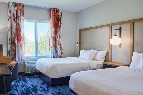 a hotel room with two beds and a window at Fairfield Inn & Suites Burlington in Burlington