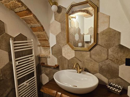 a bathroom with a sink and a mirror at DESTASU' Apartments in Castel del Monte